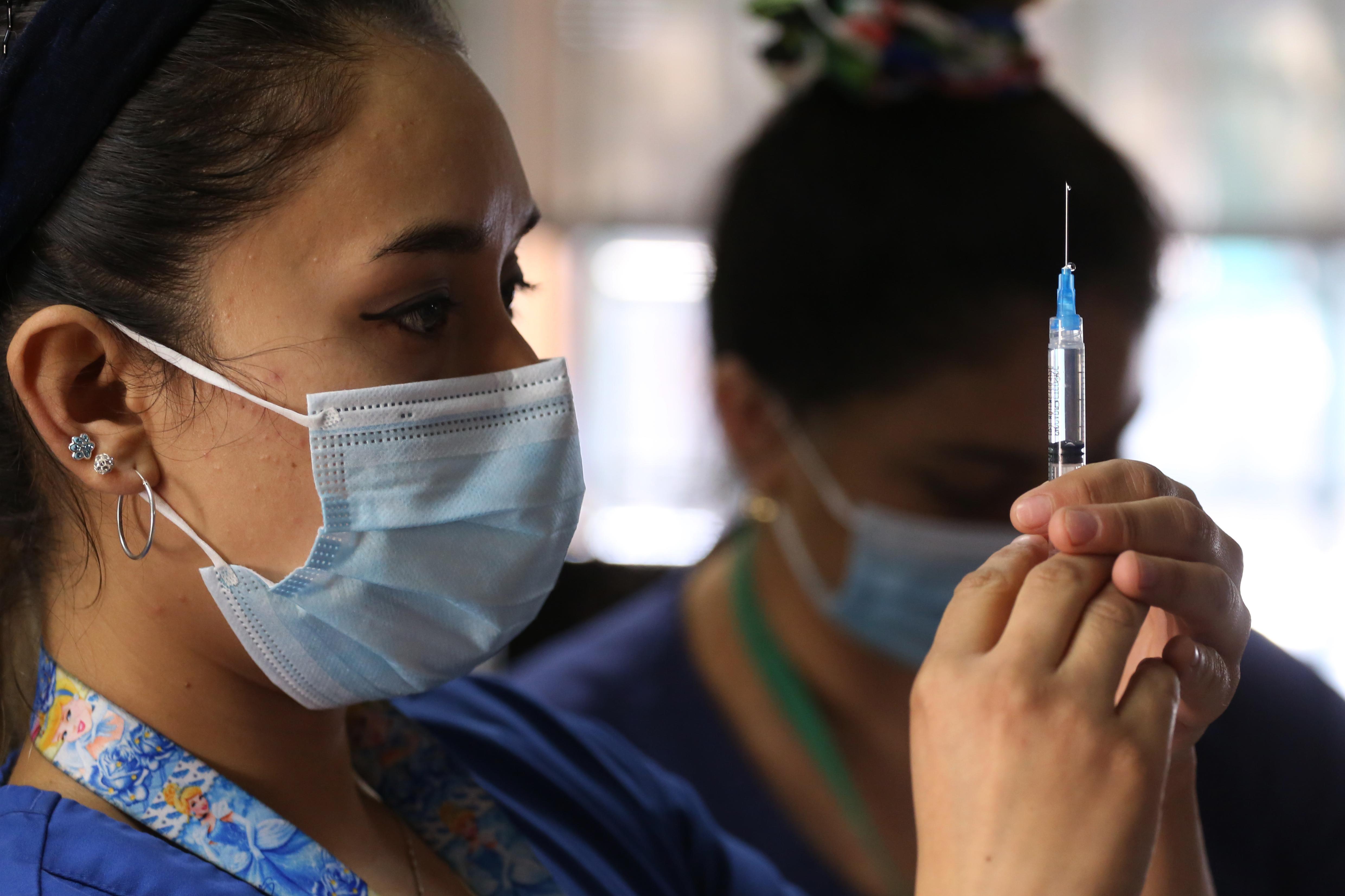 On 23 February in Santiago Chile, a health worker prepares a syringe filled with a dose of vaccine against COVID-19 during a campaign to vaccinate teachers. Photo: UNICEF/UN0429453/González