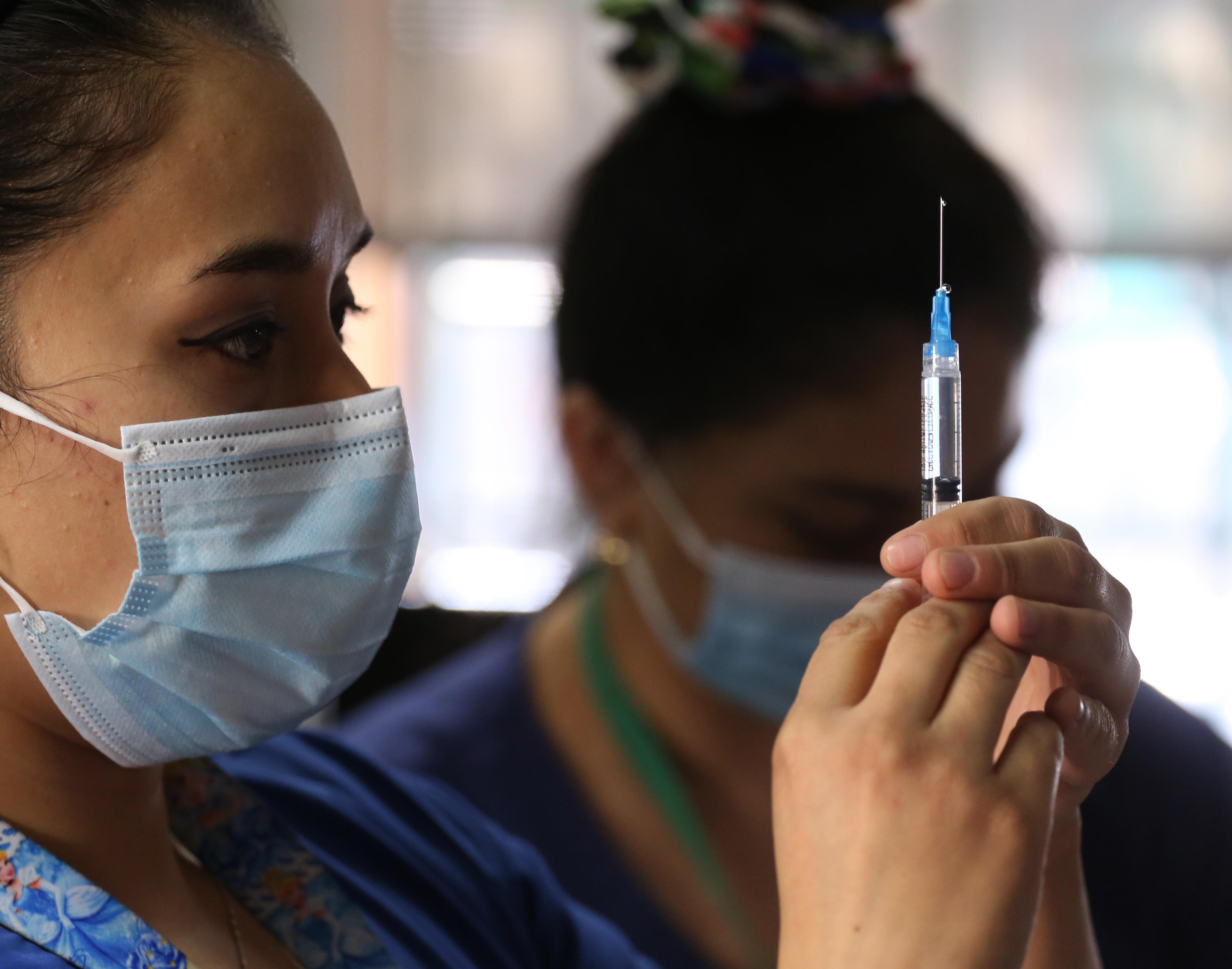 On 23 February in Santiago Chile, a health worker prepares a syringe filled with a dose of vaccine against COVID-19 during a campaign to vaccinate teachers. Photo: UNICEF/UN0429453/González