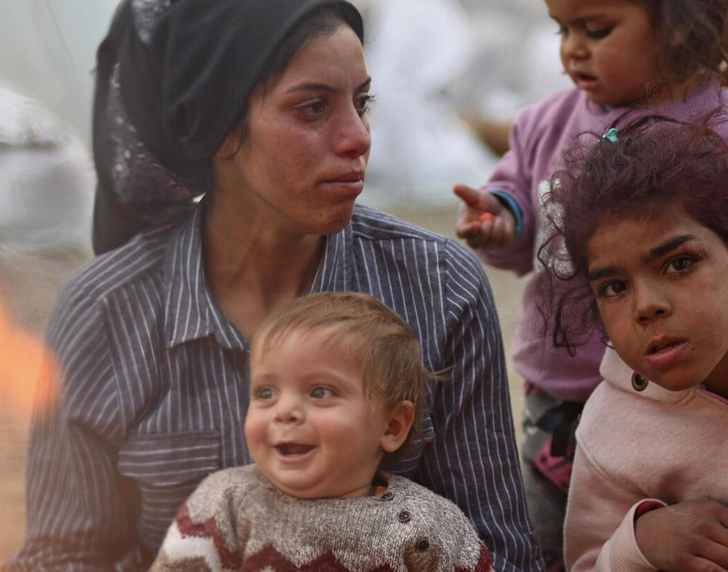 Survivors of the 7.7 magnitude earthquake keep warm by a fire in a temporary shelter in Kahramanmaraş, Turkey. The affected region of south-east Turkey and Syria was already severely disrupted by the nearly 12-year conflict in Syria, and ethnic tensions in Turkey. © UNICEF/Ölçer