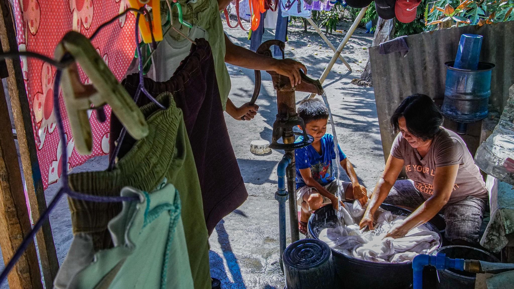 Dory Olinoy is joined by her two sons while doing the laundry. The two boys, both minors, are forbidden to get out of the streets to play amidst the coronavirus crisis. Dory has to involve them in household chores for them to learn more while the city is still on a community quarantine. Photo: Louie Pacardo / UN Women