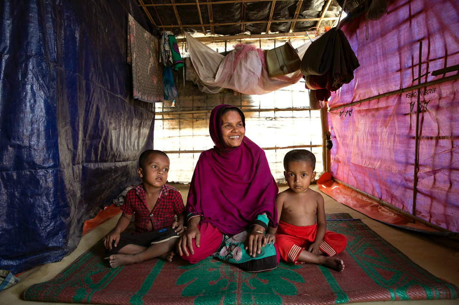 A woman sits for a photo with her children in Balukhali camp March 6, 2018. As of January 2018, UN Women has set up the first Multi-Purpose Women's Centre in the Balukhali refugee camp in Cox’s Bazar, in partnership with Action Aid and with support from UN Women National Committee Australia. Photo: UN Women/Allison Joyce